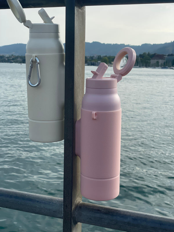 Twee Gloup Grips in Dune creme en Dusty blush aan hun karabiner aan een reling boven het water